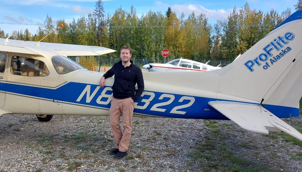 Student posing next to ProFlite of Alaska aircraft N8322 on the ramp