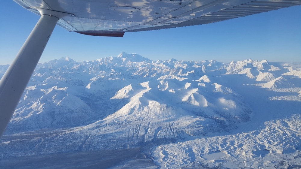 Aerial view of snow-covered Alaska mountain range from ProFlite aircraft