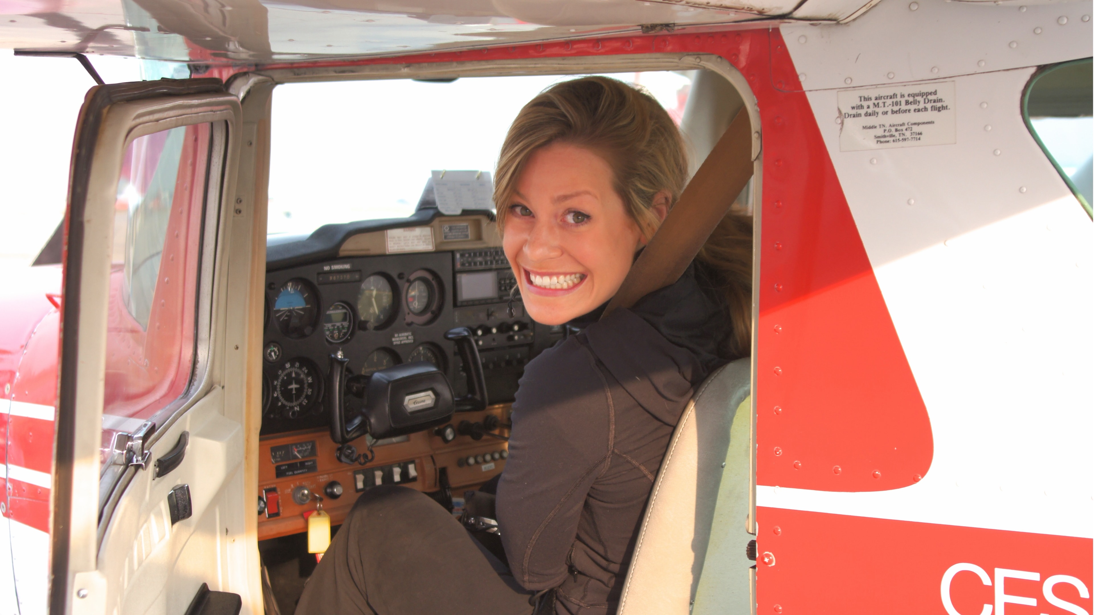 Student smiling from the cockpit door of a ProFlite Cessna training aircraft