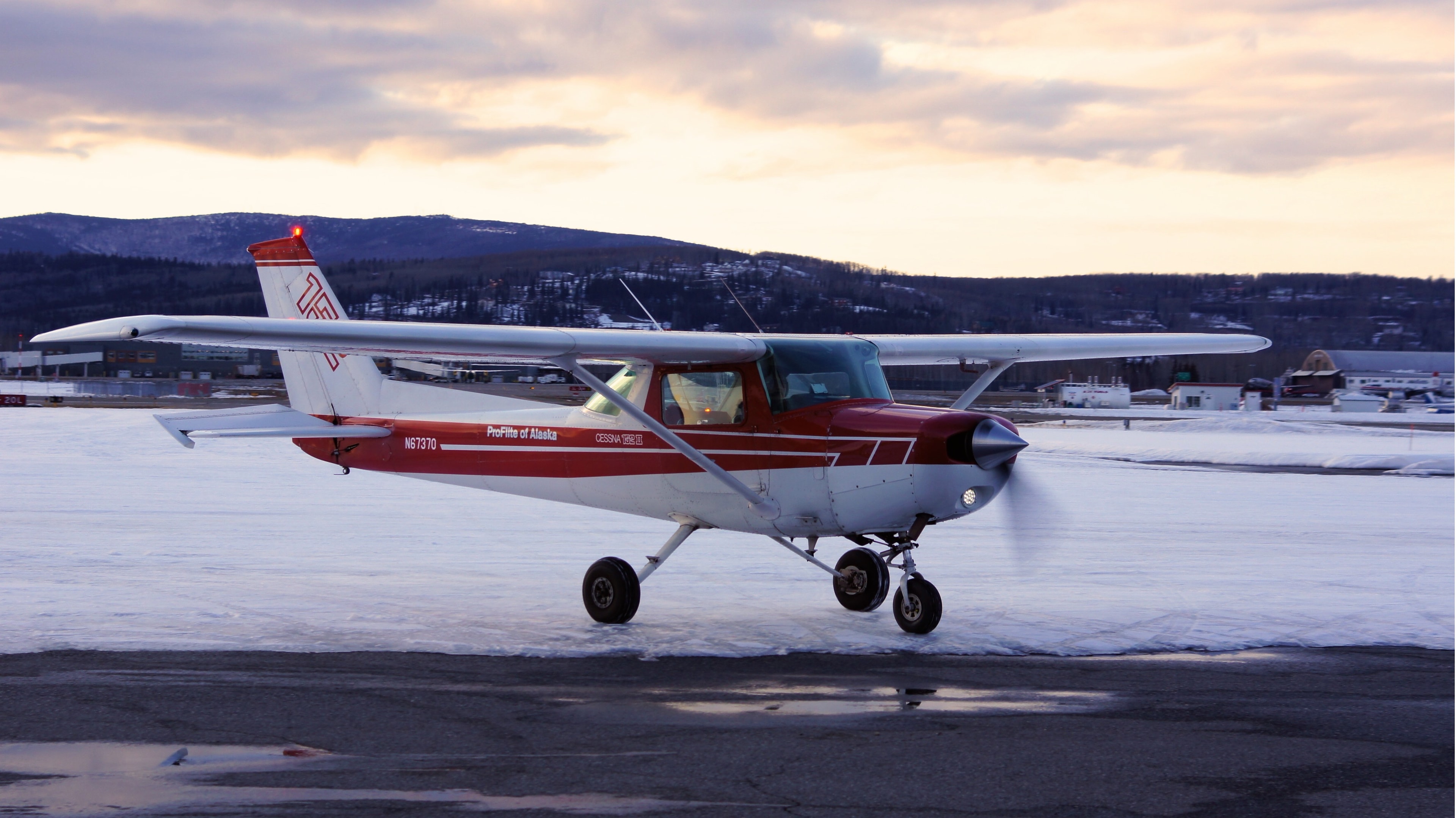 ProFlite of Alaska N67370 Cessna 152 taxiing on a snowy Fairbanks ramp at dusk