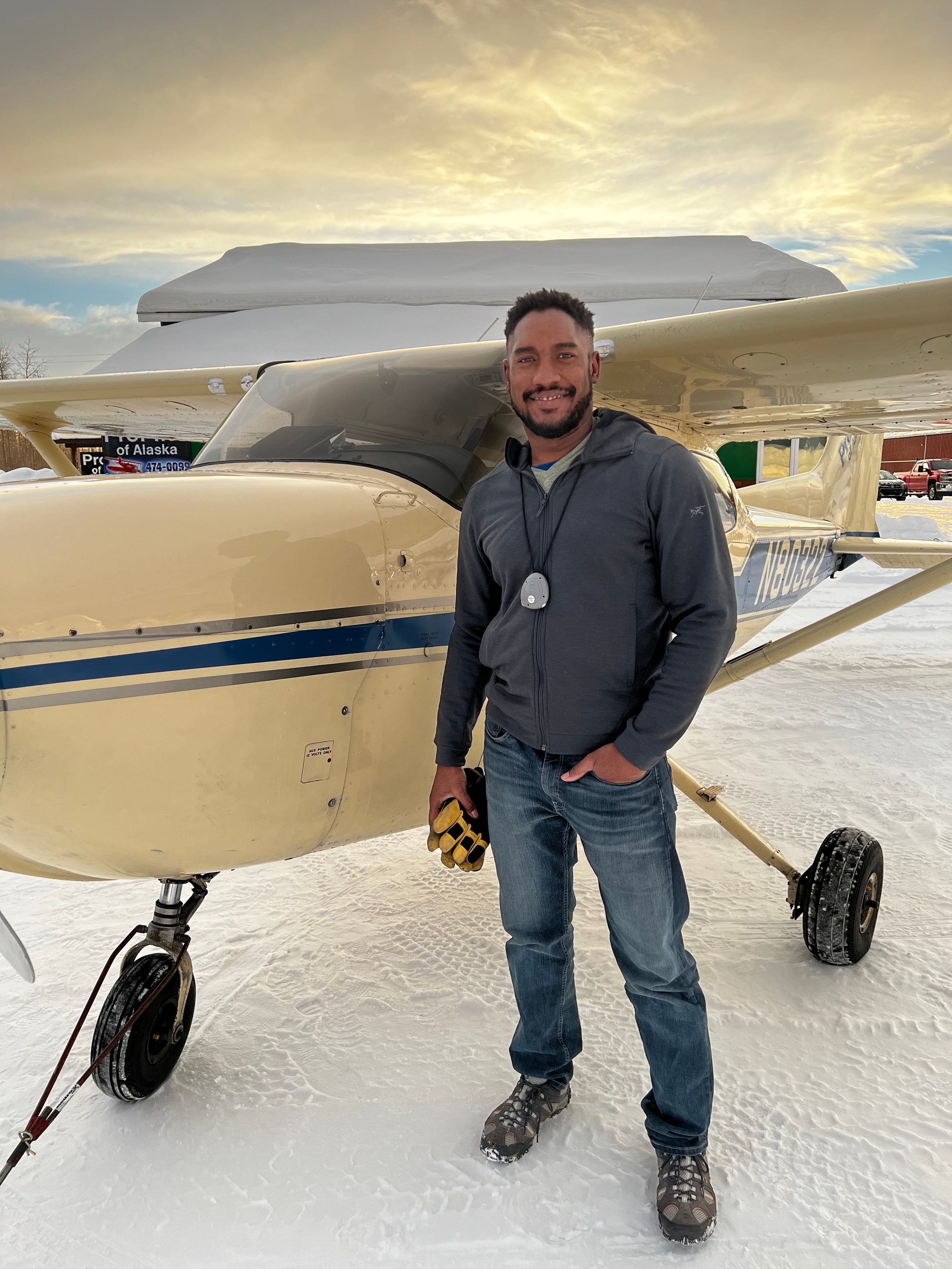 Student pilot smiling next to a ProFlite Cessna on a frozen Fairbanks ramp in winter