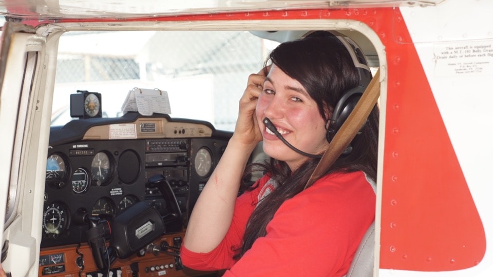 Student pilot smiling in the cockpit of a ProFlite of Alaska Cessna training aircraft